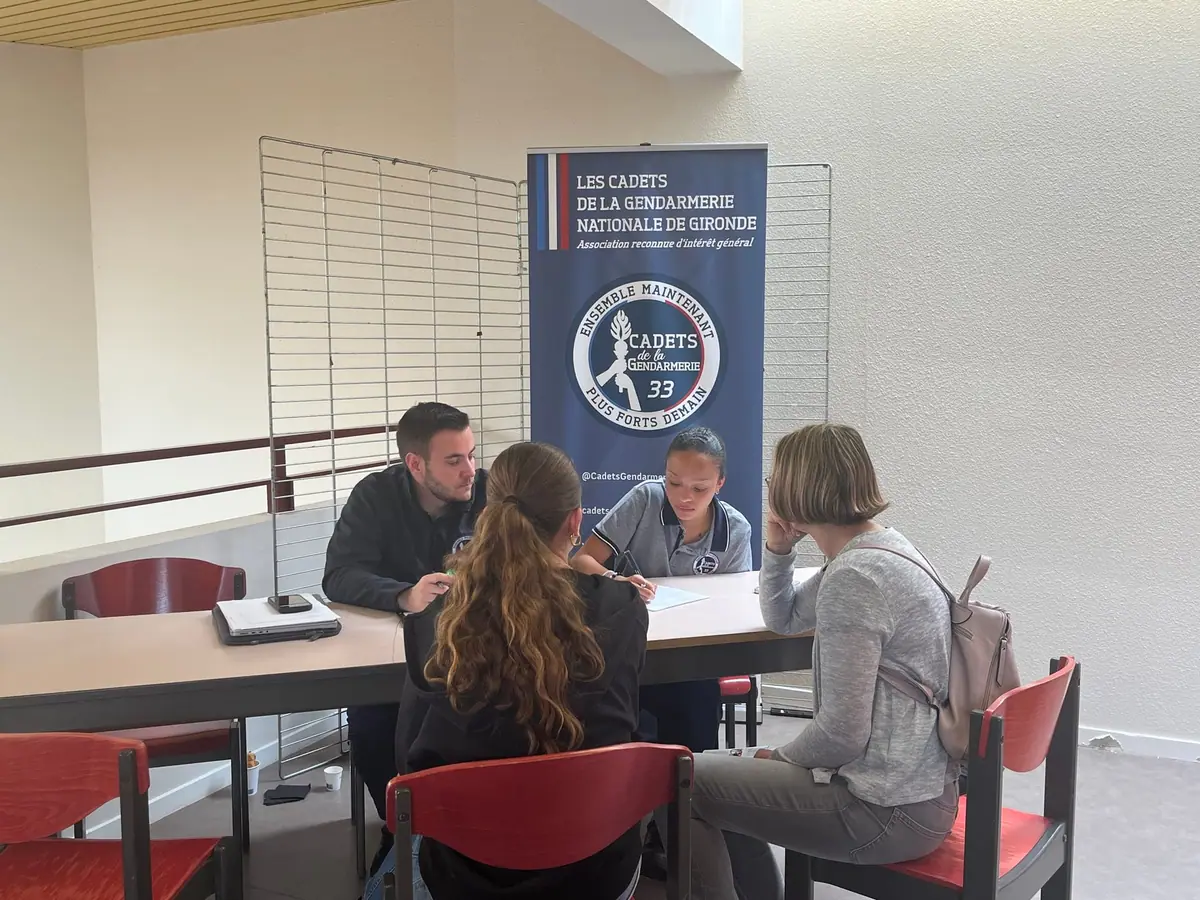 Un cadet et un référent aident une candidate et sa mère à remplir le dossier d'inscription
